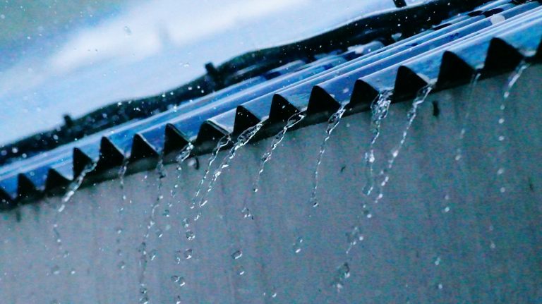Agua de lluvia cayendo desde un techo