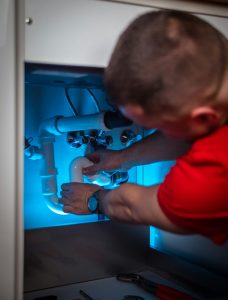 Servicio de gasfitería: instalación de tuberías debajo de un lavadero
