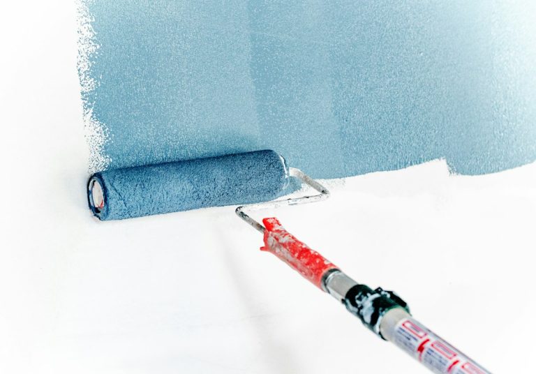 Trabajos de pintura: rodillo aplicando pintura sobre una pared